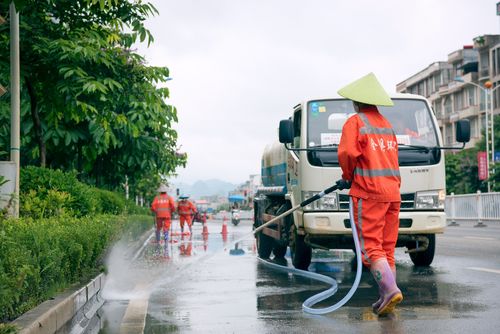 道路清洁工人正在用高压水枪清洁马路.